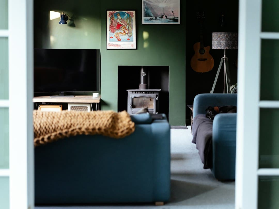 A cozy green living room with a television and a blue sofa, set up for Pixlar8k premium IPTV