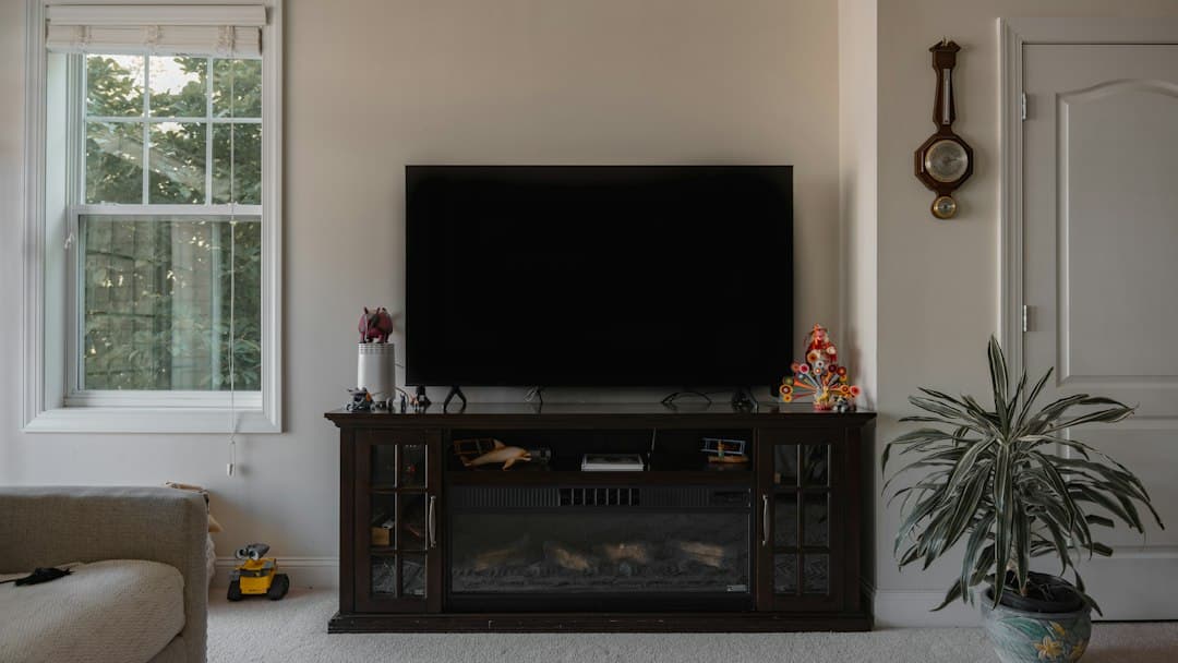 A bright living room with a wall-mounted television and plants, ready to stream live TV with Pixlar8k