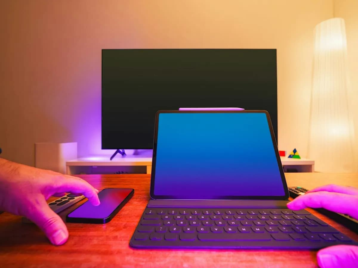 A tablet, a smartphone and a remote on a desk in front of a flat-screen TV, ready to test a Pixlar8k free trial
